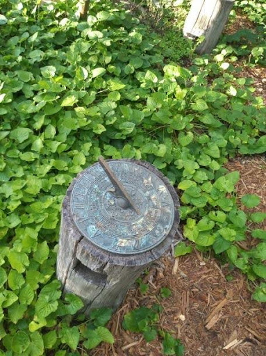 A garden sundial at Tanglewood Farm symbolizes the gardener's role in preparing and protecting plants to ensure they flourish. Reflect on the timeless care and attention needed for growth and resilience in every garden.